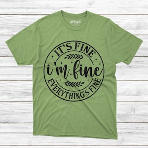 May include: Green t-shirt with a black circle graphic that says "It's Fine I'm Fine Everything's Fine" with a floral design.