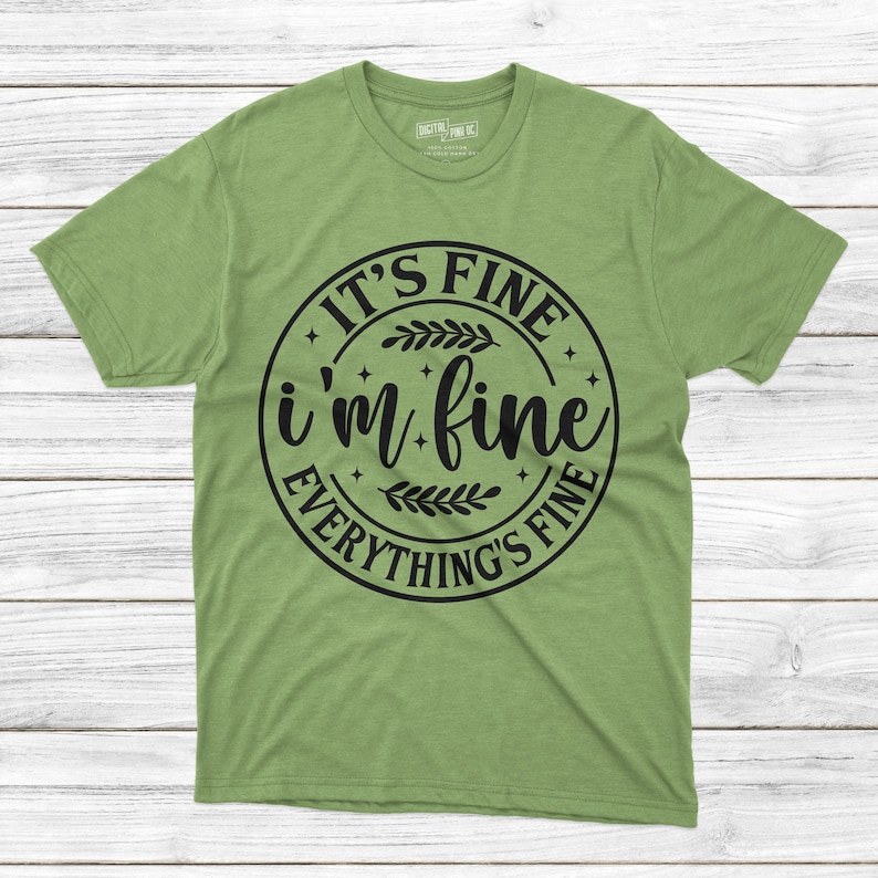 May include: Green t-shirt with a black circle graphic that says "It's Fine I'm Fine Everything's Fine" with a floral design.
