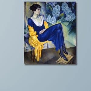 以下が含まれることがあります： 額縁に入った絵画は、黄色のショールを着た青いドレスの座っている人物を描いています。このアートワークは、青と白の花の要素を背景に、黒髪の女性を特徴としています。絵画は水色の壁に展示されています。