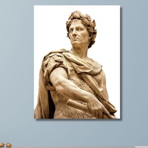 May include: A framed print of a classical sculpture of a man wearing a laurel wreath and draped in a toga. The sculpture is a light brown colour and is set against a white background.