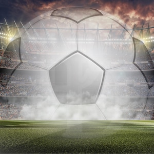 Könnte beinhalten: Ein großer weißer Fußball mit schwarzen Paneelen steht vor einem großen Stadion, das mit Zuschauern gefüllt ist. Der Ball ist teilweise von einer Wolke aus weißem Rauch verdeckt.