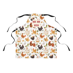 May include: A white apron with a black adjustable strap and a pattern of colorful chickens. The text "Bok Bok Bitch" is printed in red on a white rectangle in the center of the apron.