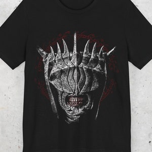 May include: Black t-shirt featuring a white graphic of the One Ring from "The Lord of the Rings" with the inscription "One Ring to rule them all, One Ring to find them, One Ring to bring them all and in the darkness bind them" in red.