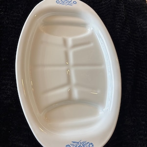 May include: White oval serving platter with divided sections. The platter has a glossy finish and is decorated with blue floral accents at each end. The divided sections are designed for serving multiple dishes.