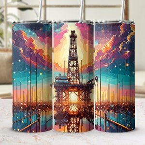 May include: A set of three stainless steel insulated tumblers with a colorful illustration of an oil rig at sunset. The design features a vibrant sky with shades of pink, orange, and blue, and a starry night sky.