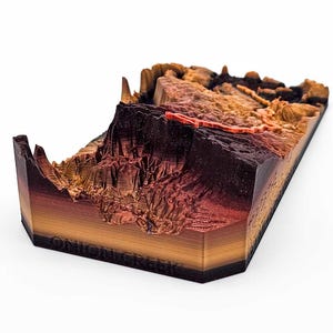 May include: A 3D printed model of a canyon landscape, with a red river winding through it. The model is made of layered wood and has a dark brown base. The text "ONIGIN CREEK" is printed on the base.
