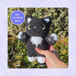 May include: A handmade black and white crochet cat plushie with yellow eyes and a white chest. The cat has white paws with gray paw pads. A circular graphic in the upper left corner reads "PDF PATTERN ONLY".