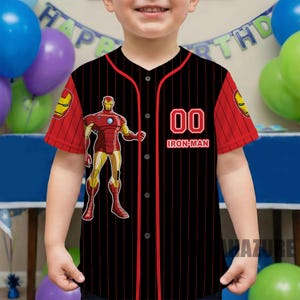Puede incluir: Camiseta de b&eacute;isbol negra y roja con un dise&ntilde;o de Iron Man. La camiseta tiene un cuerpo negro con rayas rojas y mangas. El n&uacute;mero "00" y "Iron-Man" est&aacute;n en la parte delantera. El logotipo de Iron Man est&aacute; en las mangas.