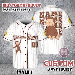 May include: A white baseball jersey with brown pinstripes, displaying a Curious George design. The front has "Curious George" and the number "00". The back features the name "NAME" and a Curious George illustration.