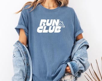 May include: A blue t-shirt with white text that reads "RUN CLUB" and a white running shoe graphic.