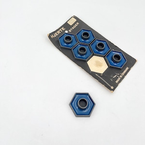 May include: A pack of six blue and black hexagonal candle holders with the text "HJERTE STAGER" and "MADE IN DENMARK".