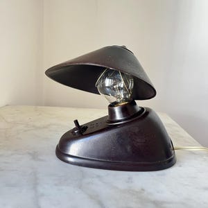 Può includere: Una tazza di ceramica bianca con un manico nero e la scritta "But First, Coffee" in nero, con un carattere a mano. La tazza è su una superficie bianca.