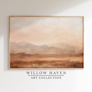 May include: A framed landscape painting with a warm color palette. The artwork depicts a mountain range in the distance, with a hazy sky and a foreground of earth tones. The text "WILLOW HAVEN ART COLLECTION" is at the bottom.