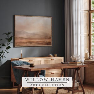 May include: A framed landscape painting in warm earth tones hangs above a wooden cabinet. A wooden desk and blue chair are in front of the cabinet. The text "WILLOW HAVEN ART COLLECTION" is displayed on a white banner.