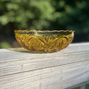 A vintage 8 inch honey amber glass bowl in medallion starburst pattern by Anchor Hocking