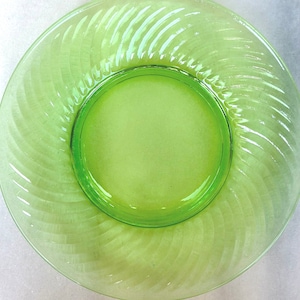 A vintage 8 inch salad plate in uranium glass green with a swirl optic edge, depression glass luncheon plate