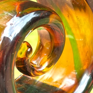 A vintage Murano ribbon  art glass swirl sculpture in amber and green color with black base 14 inches tall