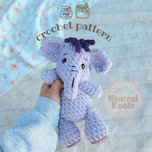 May include: A light purple crochet elephant plush toy with dark purple hair, black eyes, and grey feet. The image includes the text "crochet pattern" and "Neutral Knots" with icons of a PDF file and a honey pot, indicating a digital craft guide.