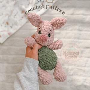 Peut inclure: Un modèle au crochet pour une peluche représentant un personnage rose semblable à un porcelet avec de grandes oreilles, des yeux noirs et un museau rose foncé. Le personnage porte un haut vert texturé. L'image inclut le texte PDF, une icône de pot de miel et Neutral Knots.