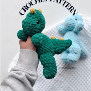 May include: A green crochet dinosaur with yellow accents and a blue crochet dinosaur in the background. The text "CROCHET PATTERN" is arched above the dinosaurs. The Instagram handle @neutral.knots is in the bottom right corner.
