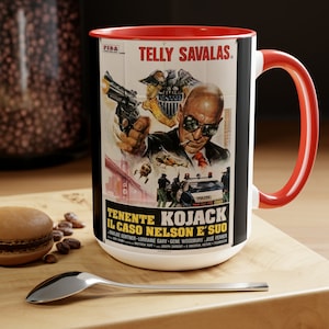 May include: A white ceramic mug with a red handle. The mug features a black and white image of Telly Savalas as Lieutenant Kojack from the TV show Kojak. The image includes the text "Telly Savalas" and "Tenente Kojack Il Caso Nelson E' Suo".