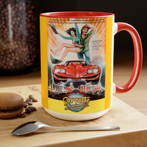 Könnte beinhalten: Eine gelbe und rote Keramiktasse mit weißem Innenraum. Die Tasse zeigt ein Vintage-Filmplakat-Design mit einem roten Corvette-Sportwagen, einem Mann und einer Frau sowie dem Text "Corvette Summer".
