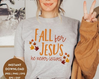 May include: A gray t-shirt with the text "FALL for JESUS he never leaves" in orange and white lettering. The shirt is decorated with orange, red, and yellow autumn leaves.