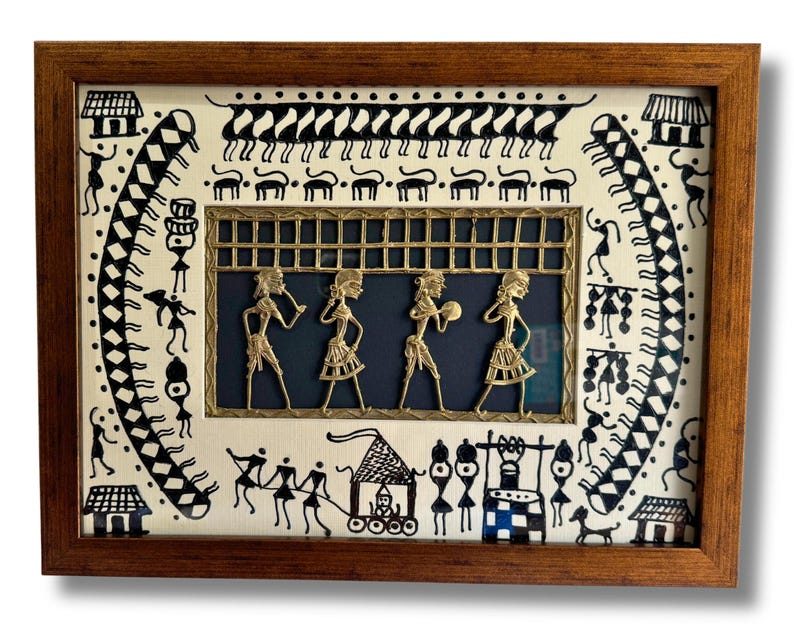 May include: A framed artwork depicting a traditional Indian folk art scene with black and white figures and a gold-coloured metal panel with figures in the centre. The artwork is set against a white background.