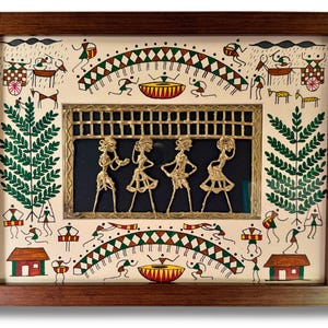 May include: A framed artwork featuring a traditional Indian folk art style. The artwork depicts a central panel with four figures in a dancing pose, crafted from brass and set against a dark blue background. The surrounding frame is decorated with a white background and colourful illustrations of people, animals, and plants.