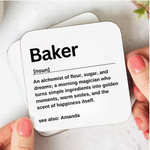 May include: Square white coaster featuring the word "Baker" in black, bold text. The coaster has a definition of "Baker" as a noun, describing the art of baking. The text also includes "see also: Amanda".