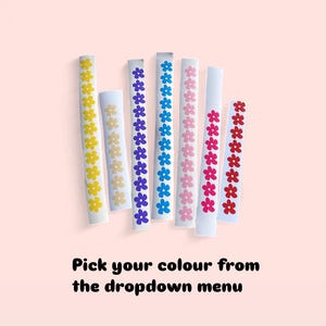 Puede incluir: Una variedad de pegatinas rectangulares blancas, cada una adornada con una fila de dise&ntilde;os florales coloridos. Las flores son en tonos amarillo, morado, azul, rosa y rojo. El texto en la parte inferior dice "Pick your colour from the dropdown menu."