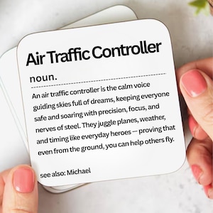 May include: A white square coaster with rounded corners, featuring the text "Air Traffic Controller" in bold black letters. The coaster includes a definition and description of the profession. The text "see also: Michael" is also present.