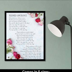 May include: A printable wall art design featuring the lyrics to the hymn "Blessed Assurance". The lyrics are printed on a blue background with white text and are surrounded by pink and white flowers. The design is available in five sizes: 5x7, 8x10, 11x14, 16x20, and 20x24 inches.