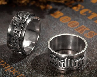 May include: Two silver rings with engraved lettering. The ring on the left says "Always" and the ring on the right says "Still Love".