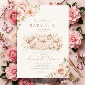 May include: A baby shower invitation with a soft pink and cream color scheme. The invitation features the text "a sweet BABY GIRL is on her way" and includes illustrations of baby items like a dress, shoes, and a stuffed bunny. Floral accents and butterflies surround the text.