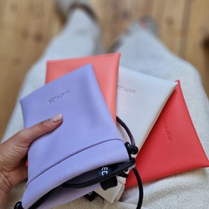 Purple, pink (coral), white, and red shoulder pouches