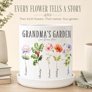 以下が含まれることがあります： 白い円筒形のセラミック製プランターと受け皿。テキストには「EVERY FLOWER TELLS A STORY」、「Their birth flowers. Their names. Your garden.」、「GRANDMA'S GARDEN」、「Love Grows Here」と書かれており、5つの花のイラストが描かれています。
