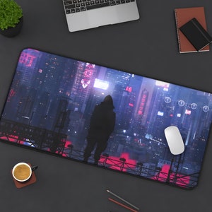 May include: A black and blue gaming mouse pad with a cityscape and a hooded figure in the foreground. The cityscape is lit up with neon lights and has a futuristic feel.