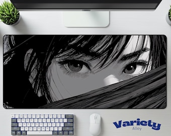 May include: Black and white mouse pad featuring an anime-style illustration of a person's eyes. The eyes are the focal point, with detailed eyelashes and eyebrows. The mouse pad has the text "Variety Alley" in blue.