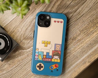 May include: A blue phone case with a retro game design. The case features a pixelated game screen with a character, a bear, and a banana. The case also has a joystick and buttons labeled "A" and "B". The text "LUCK" is displayed on the case.
