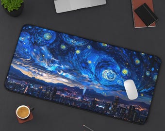 Könnte beinhalten: Ein rechteckiges Mauspad mit einer lebendigen Darstellung von Van Goghs "Sternennacht". Das Design zeigt wirbelnde blaue und gelbe Sterne über einer Stadtlandschaft. Eine weiße Maus liegt auf dem Pad, zusammen mit einem Laptop und anderem Schreibtischzubehör.