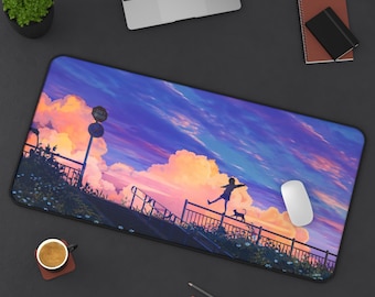 May include: A rectangular desk mat featuring a vibrant anime-style illustration of a sunset sky with clouds. A silhouetted figure balances on a railing with a cat. A computer mouse and a laptop are also visible.