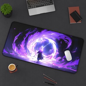 Può includere: Un tappetino per mouse da gioco nero e viola con un design a spirale viola e bianco. Una figura con un mantello nero si trova al centro del design.