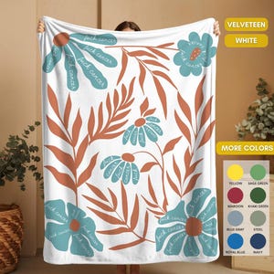 May include: White velveeteen blanket with a floral design. The blanket features teal flowers and rust-colored leaves against a white background. The text "fuck cancer" is written on the flowers. Additional color options are listed.