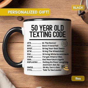 May include: White ceramic mug with a black handle and rim, featuring the text "50 YEAR OLD TEXTING CODE" and a list of acronyms with their meanings. The mug is labeled "PERSONALIZED GIFT!" and "11oz".