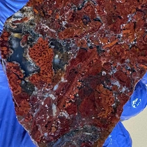 May include: A white ceramic mug with a black handle and the text "But first, coffee" in a black, handwritten-style font. The mug is on a white surface.