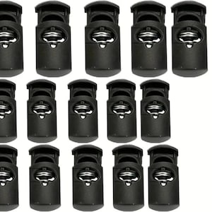 May include: A set of 12 black plastic toggle buckles with a metal spring inside. The buckles are designed for use with cord or rope.