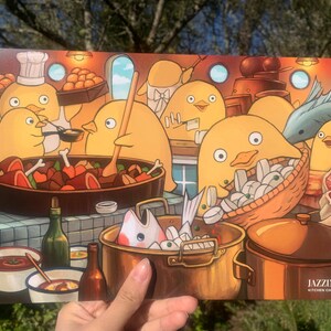 May include: A colourful illustration of a group of yellow chickens cooking in a kitchen. The chickens are wearing chef hats and aprons and are preparing a variety of dishes, including a pot of stew, a pan of fish, and a basket of clams. The illustration is titled "Jazzine Kitchen Chicks".