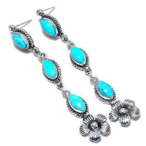 May include: A pair of silver dangle earrings with turquoise stones and flower accents.