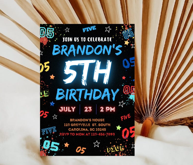 May include: A black and white birthday invitation with colorful accents. The invitation is for Brandon's 5th birthday party. It includes the date, time, and location of the party. The text "JOIN US TO CELEBRATE" is at the top of the invitation.